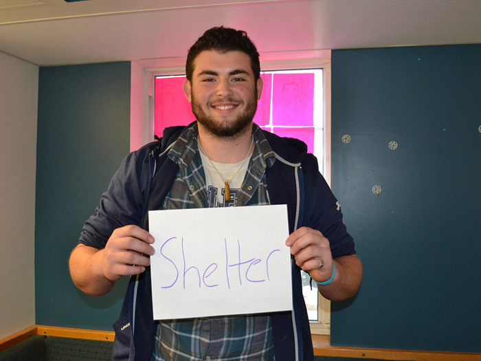 student holding sign that reads SHELTER