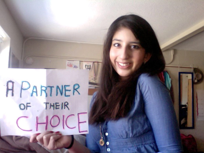 student holding sign that reads A PARTNER OF THEIR CHOICE