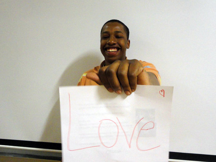 student holding sign that reads LOVE