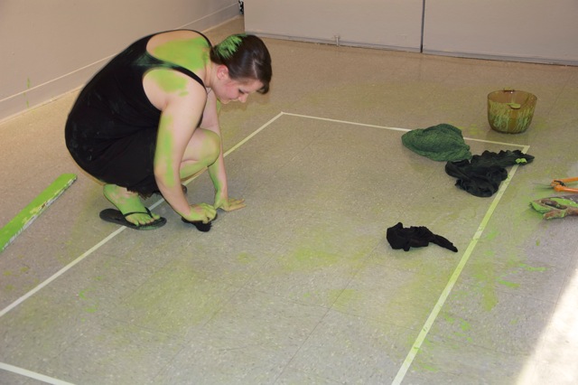 greenish woman paints a floor green