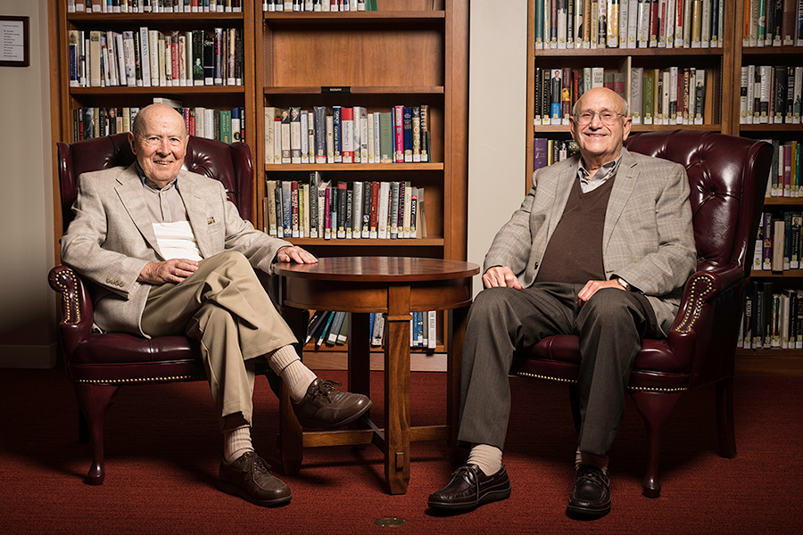 portrait of Ray Ettington (right) and Otto Muller-Girard seated in front of bookcases