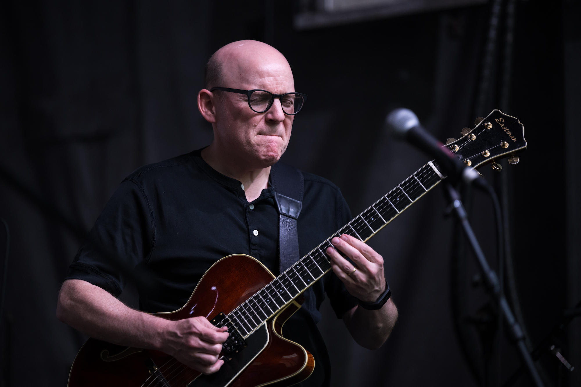 Man in glasses playing jazz guitar