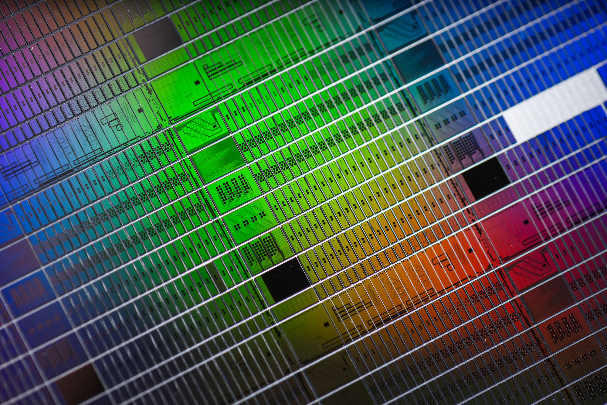 A photonic wafer with sensor chips under a rainbow spectrum of light