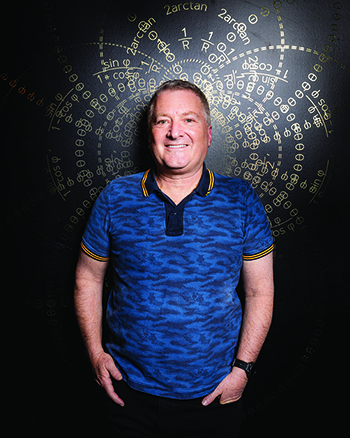 Stu Elby standing in front of wall of equations inside Sphere.