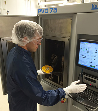 A researcher working on equipment in a lab.
