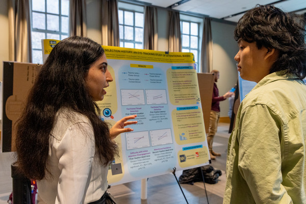 Two students discuss research poster.