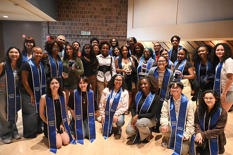 A large group of students wearing regalia pose for a picture.