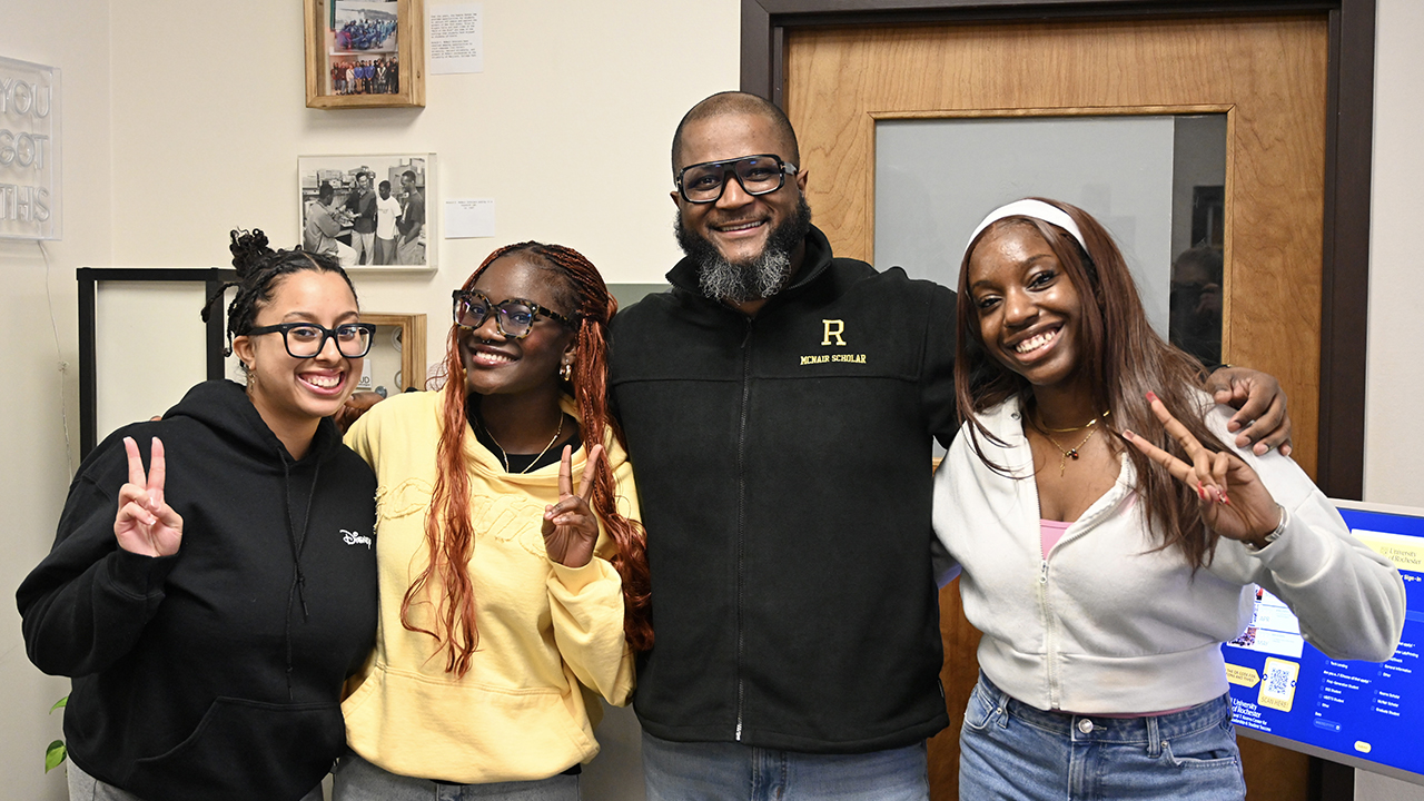 A group photo of smiling students and a staff member.
