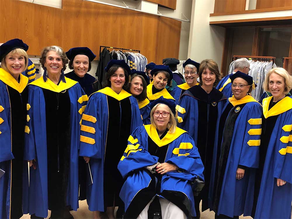 several members of the board of trustees dressed in cap and gown