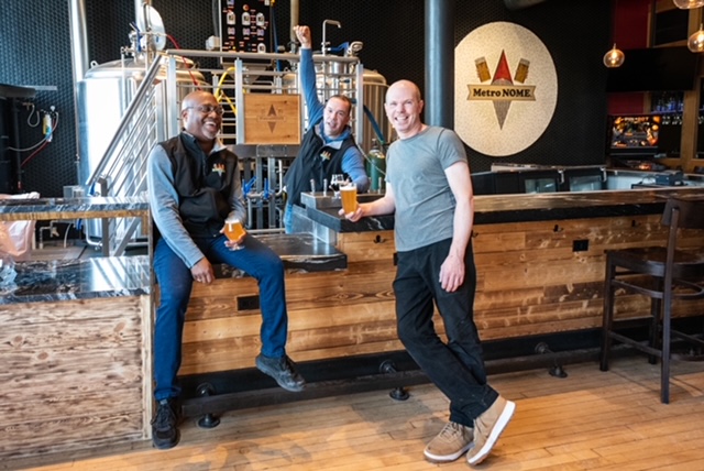 William Eddins and two other men pose in front of a counter