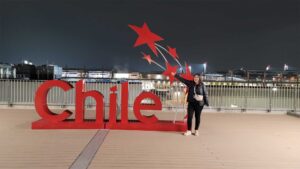 Pilar Osorio-Godoy standing in front of a sign that reads "Chile"