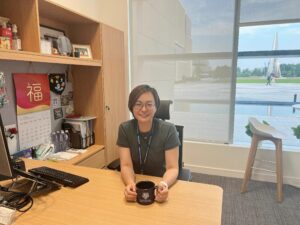 Bonnie Liu ’13S (MBA) sitting at a desk with a mug in her hands