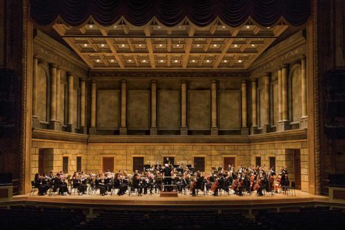 Philharmonic orchestra playing on stage at the Eastman Theatre