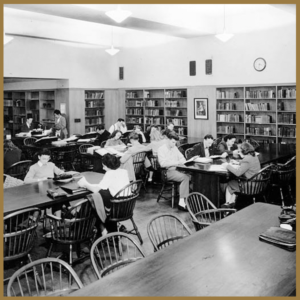 black and white image of students at tables in the library