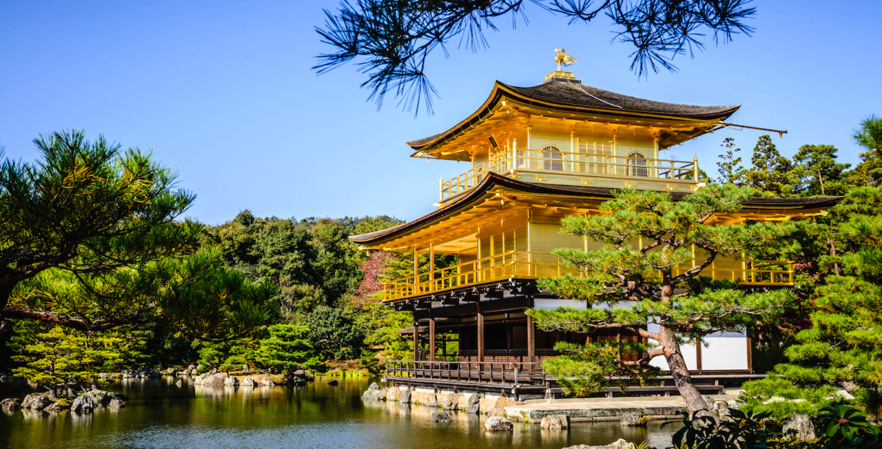 Image of yellow Japanese building, gardens, and pond