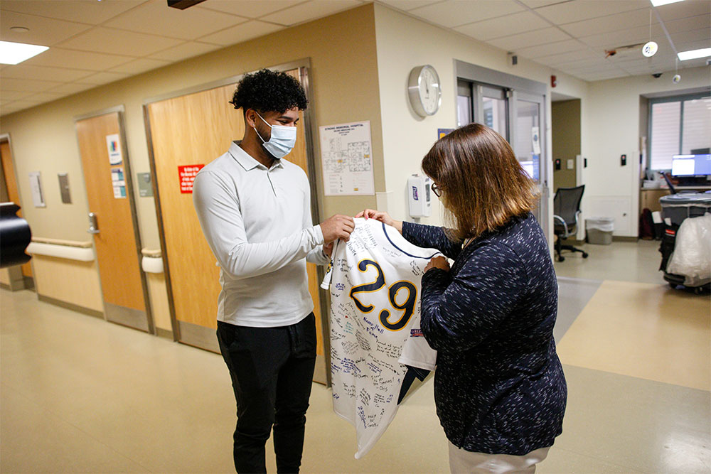 Brito is presented with a UR baseball jersey signed by URMC staff.