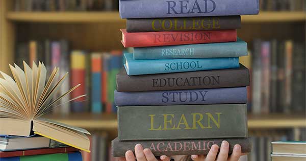 stack of books being held up by a pair of hands