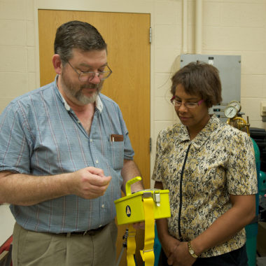 Lisa Norwood looking at a yellow box with a man