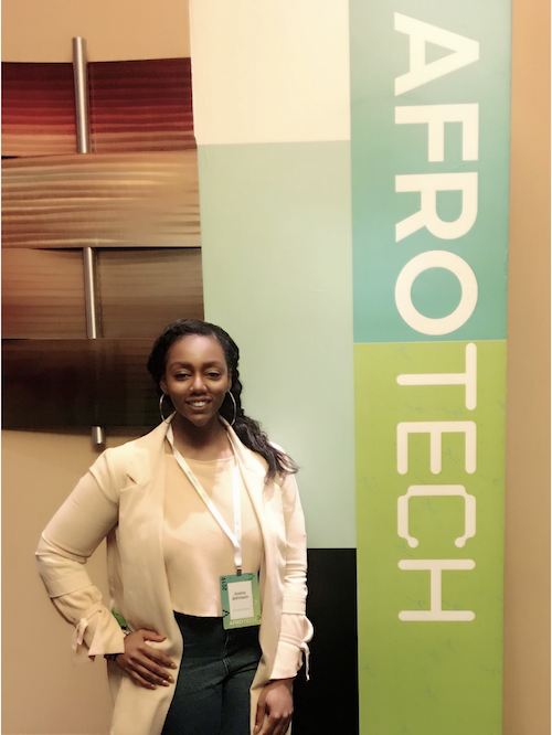 Juana Johnson in front of the AfroTech banner