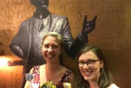 two women posing with george eastman cutout