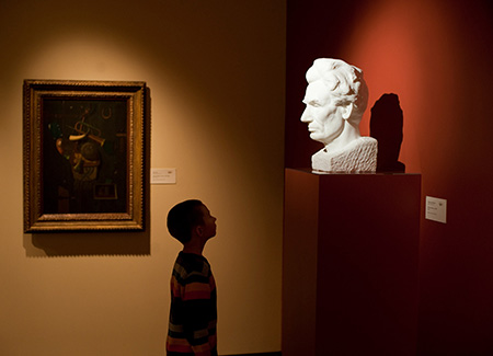 child looking at bust of Abraham Lincoln