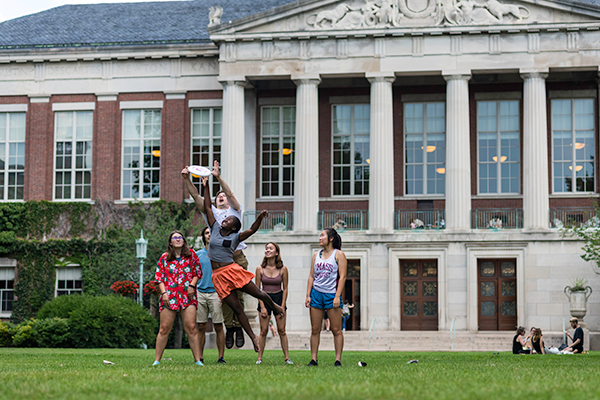 Students play frisbee on Eastman Quad.