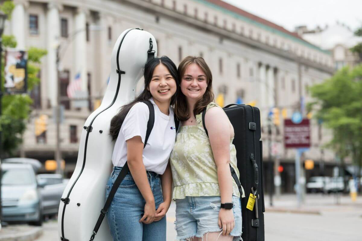 Cellist Ariunenerel Gantumur of Ulaanbaatar, Mongolia (by way of Seattle) (L) and Brynn Cogger of Seattle (viola) pause for a photo before moving into the Student Living Center as first year students of the class of 2027 move in at the University of Rochester Eastman School of Music.