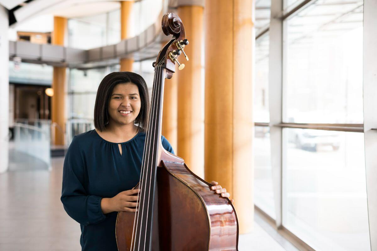 Janae Gaddy ‘24E, a double bass major at Eastman and first generation student from Lancaster, PA, is photographed in Eastman Theatre.
