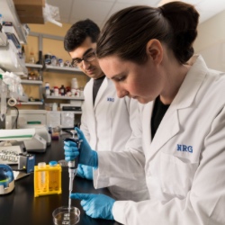 Two University of Rochester students working on an experiment in a lab.