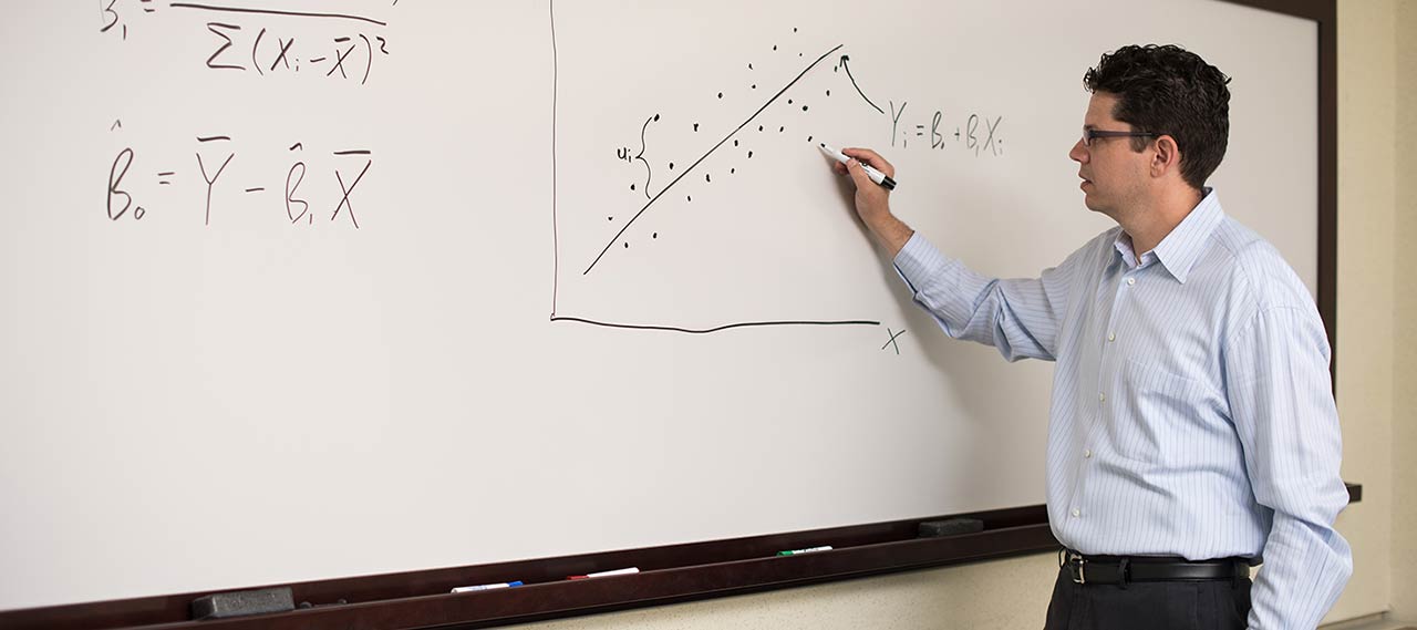 A professor writing on a white board