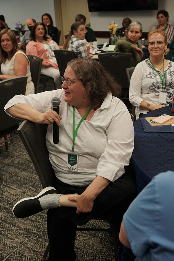 An audience member asks a question using a microphone.