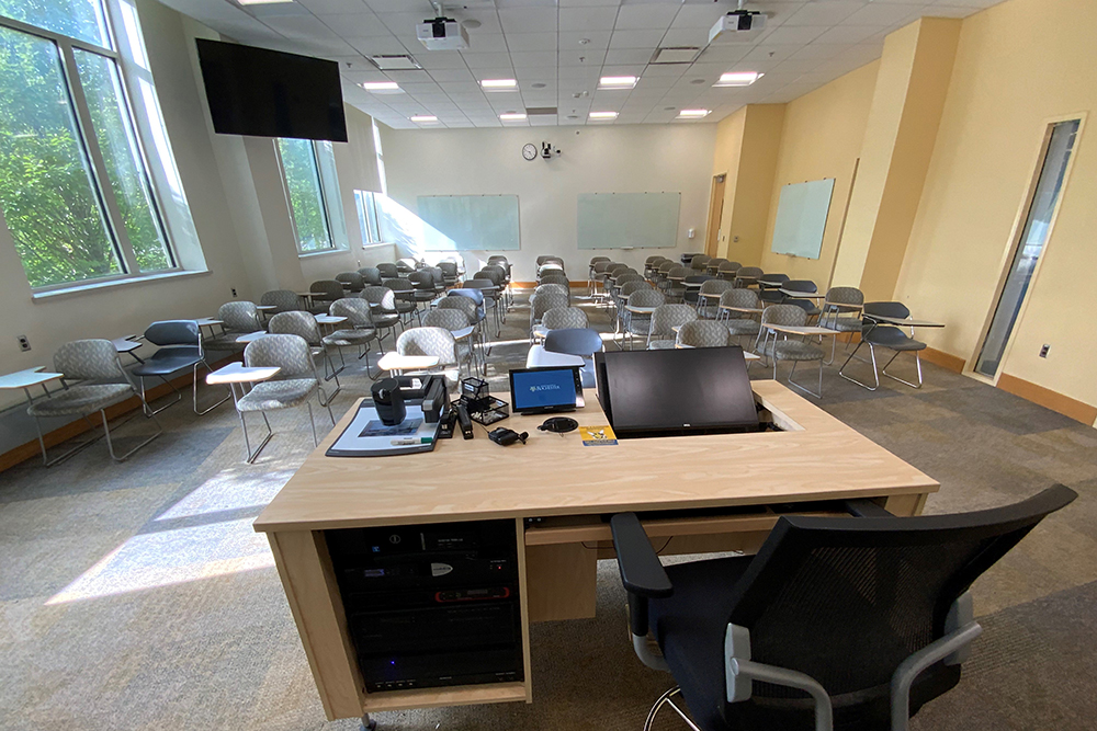 A view of a classroom from the front, behind the instructor's desk.