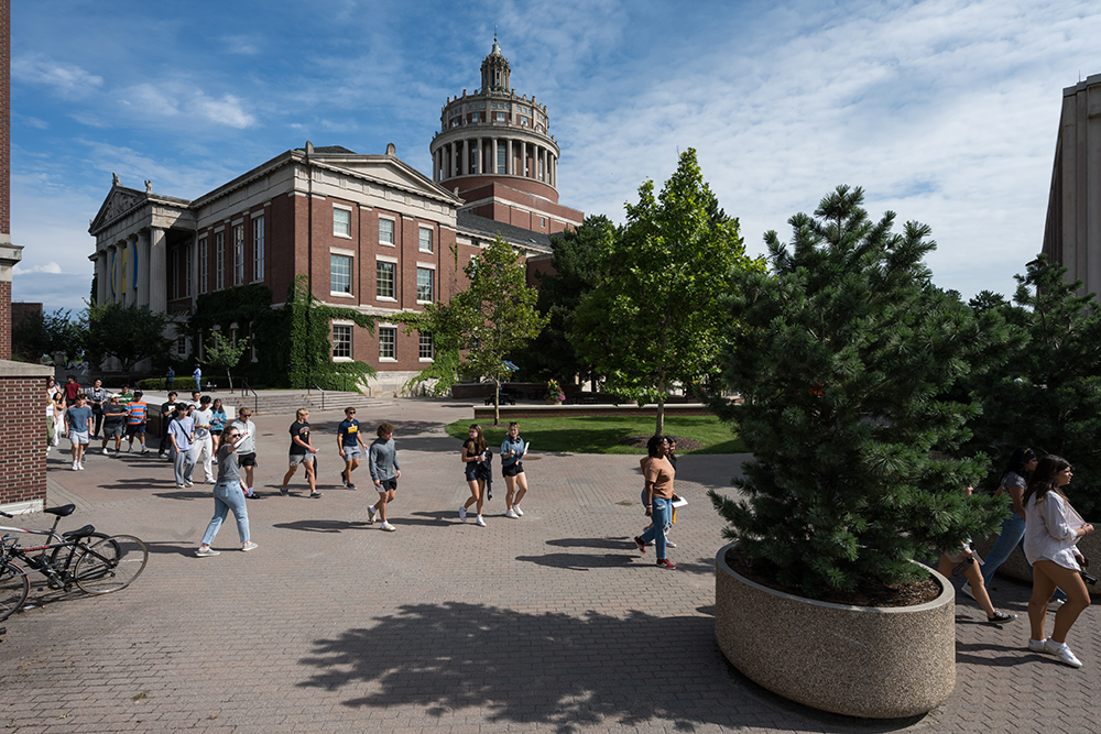 Students walking on campus on a sunny day.