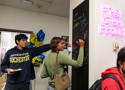 Students signing their name on a poster.