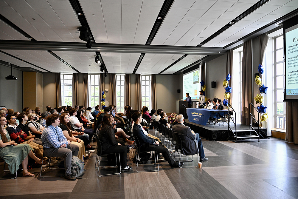 Symposium attendees listening to a speaker.