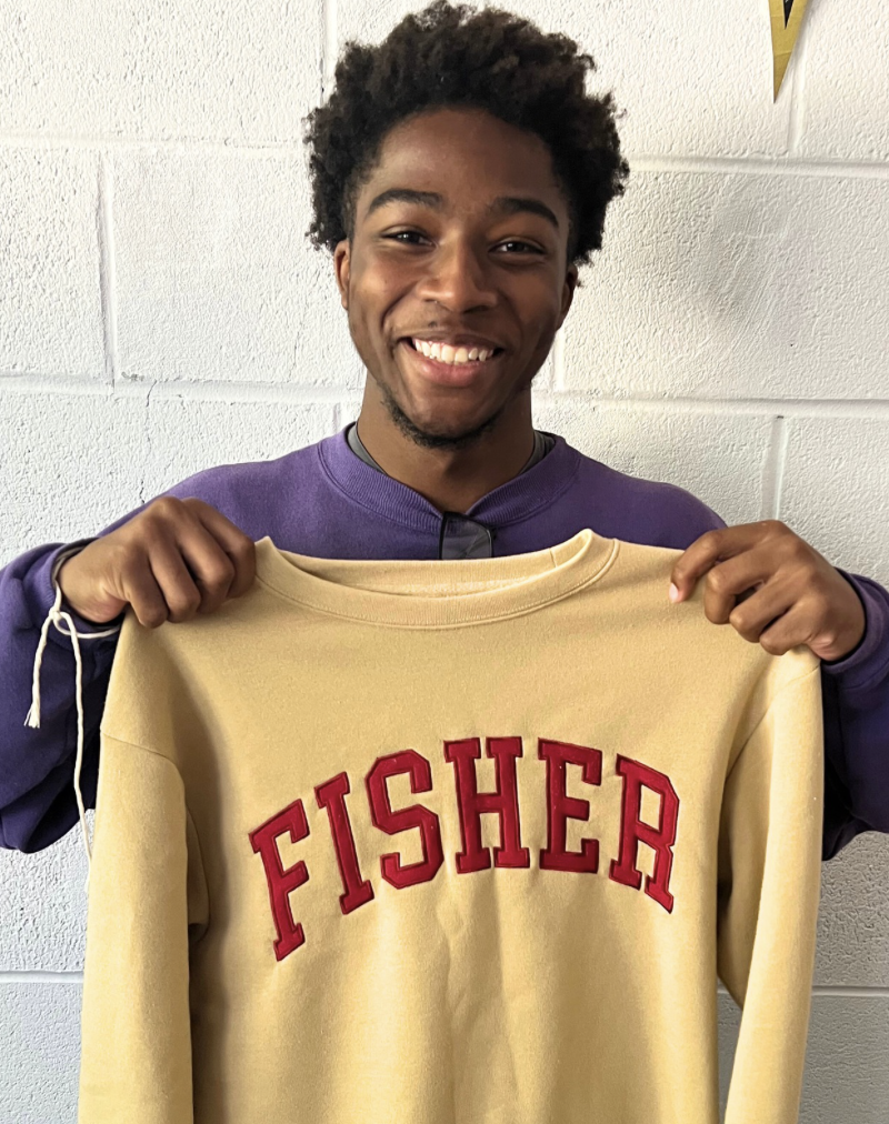 Kerel Cooper holds up a St. John Fisher University sweatshirt.