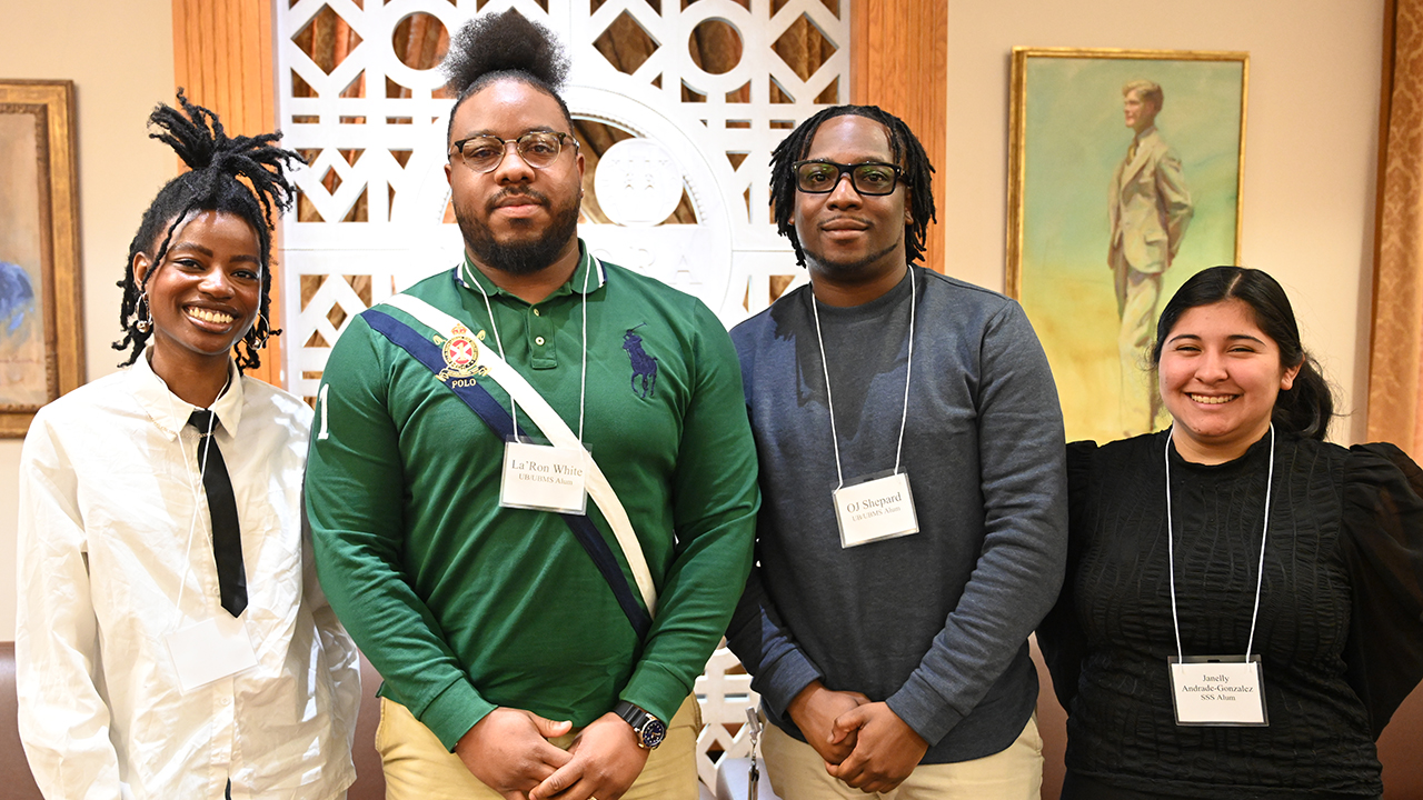 Four people smiling at the camera.