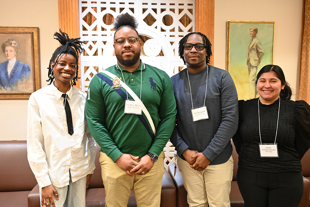 Four people smiling at the camera.