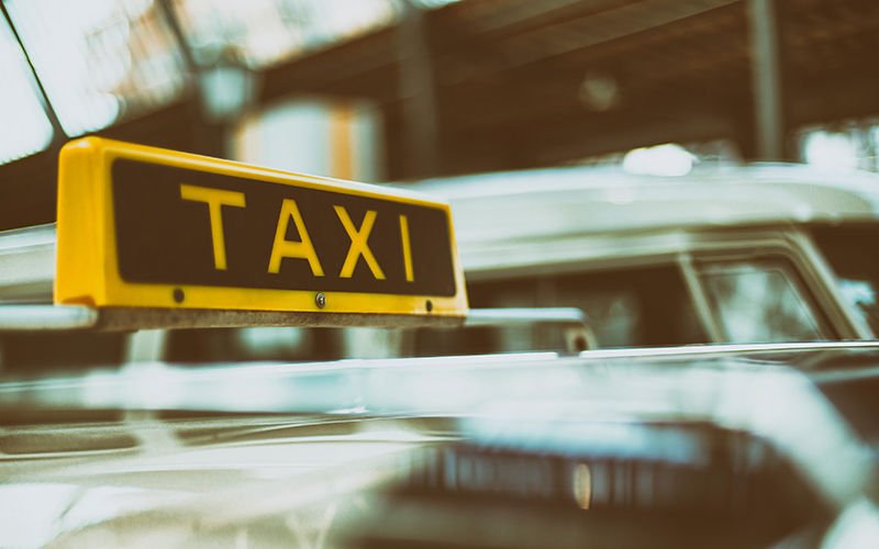 Photo of the sign atop a taxi cab that reads taxi