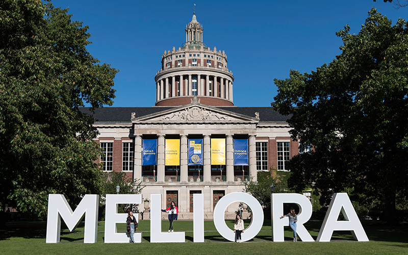 photo of students posed with the white Meliora letters on the Eastman Quad during a past Meliora Weekend