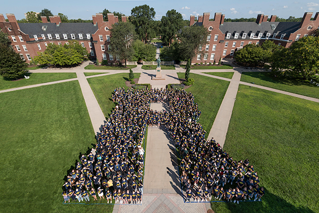 Class of 2024 students pose in the shape of an R on Wilson Quad