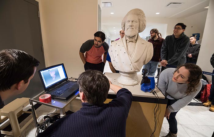 Students using technology to scan a bust of Frederick Douglass.