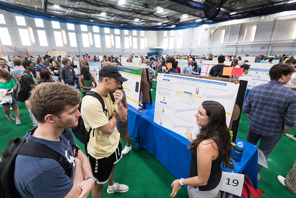 Andrew Jackson (L) and Jack Pettit (both ’23) listen as Daniella Deis ’23 (BCS, PSY) describes the poster presentation “Examining the Association Between Empathy, Emotional Support and Relationship Satisfaction in Heterosexual Couples.”