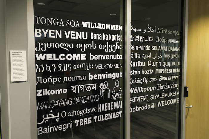 Glass wall covered with text reading "Welcome" in different languages