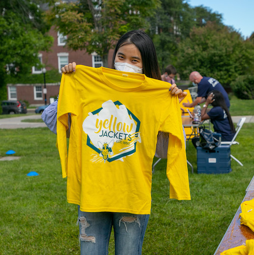 Student holding up a yellow Yellowjacket shirt