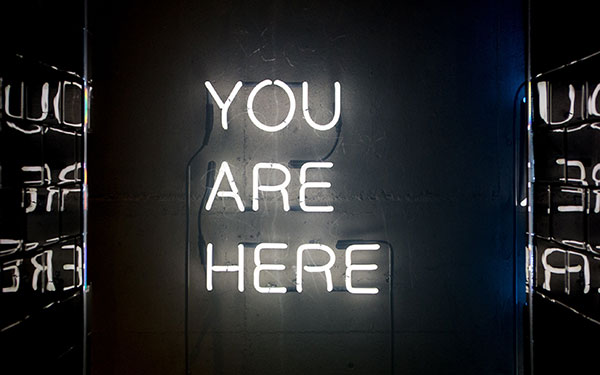 A neon sign that says "you are here".