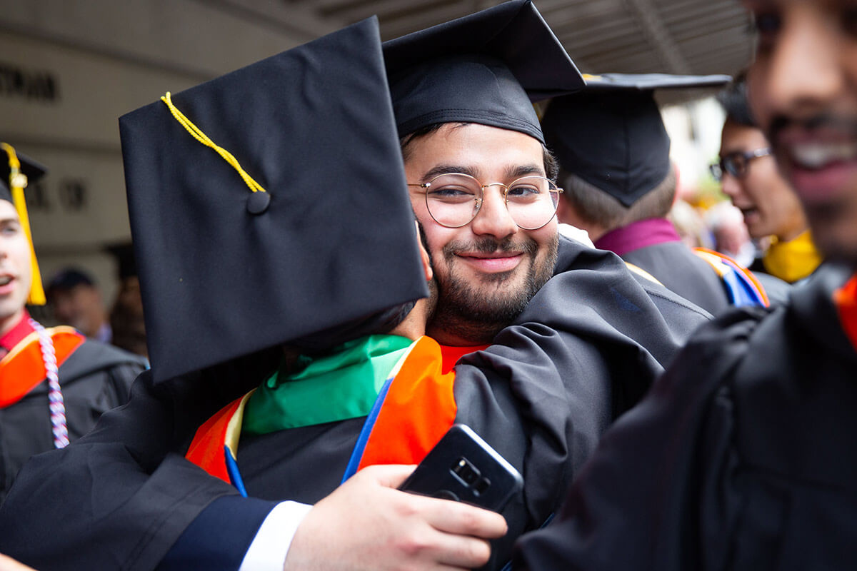 Hugging it out: Abdulmalik Kurdi is greeted by fellow engineering graduates after the ceremony. (University photo / Keith Walters)