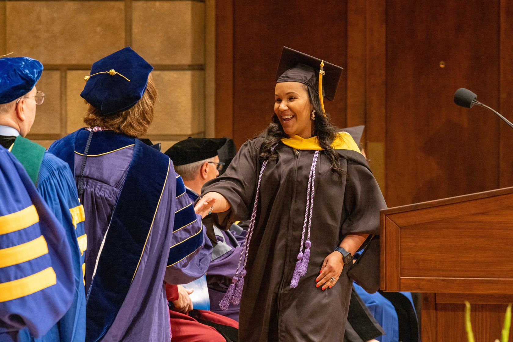 Evelyn Santos shakes hands with Dean Lisa Kitko at graduation.
