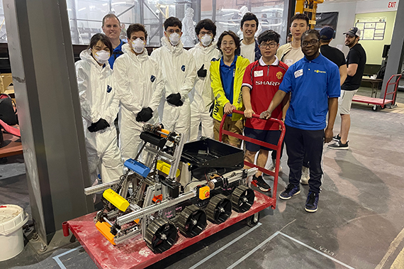 Members of the UR Robotics club pose in front of the autonomous lunar robot they built while at the Lunabotics competition in Florida.
