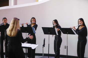 Flautists performing with a music conductor